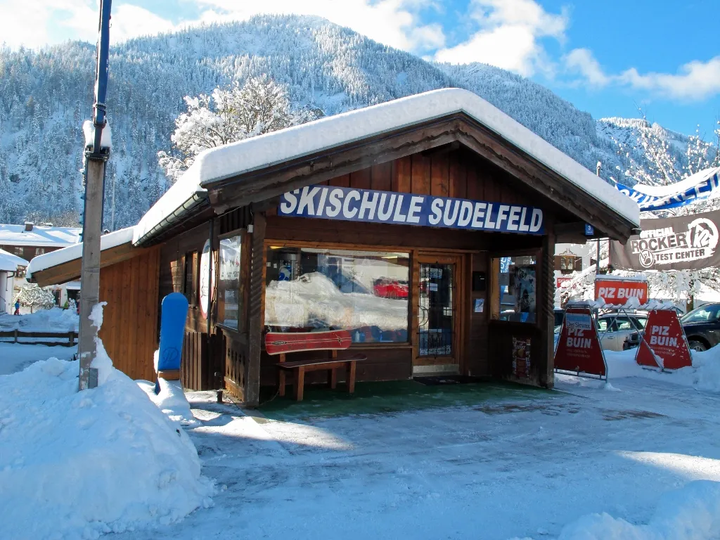 Die verschneite Holzhütte der Skischule Sudelfeld