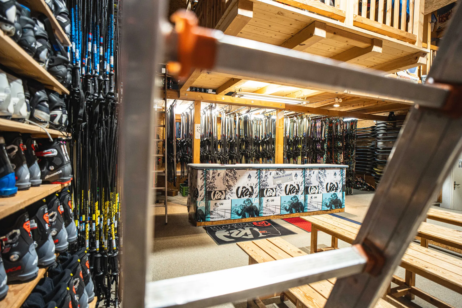 Verleihraum mit Skischuhen, Skiern und Theke