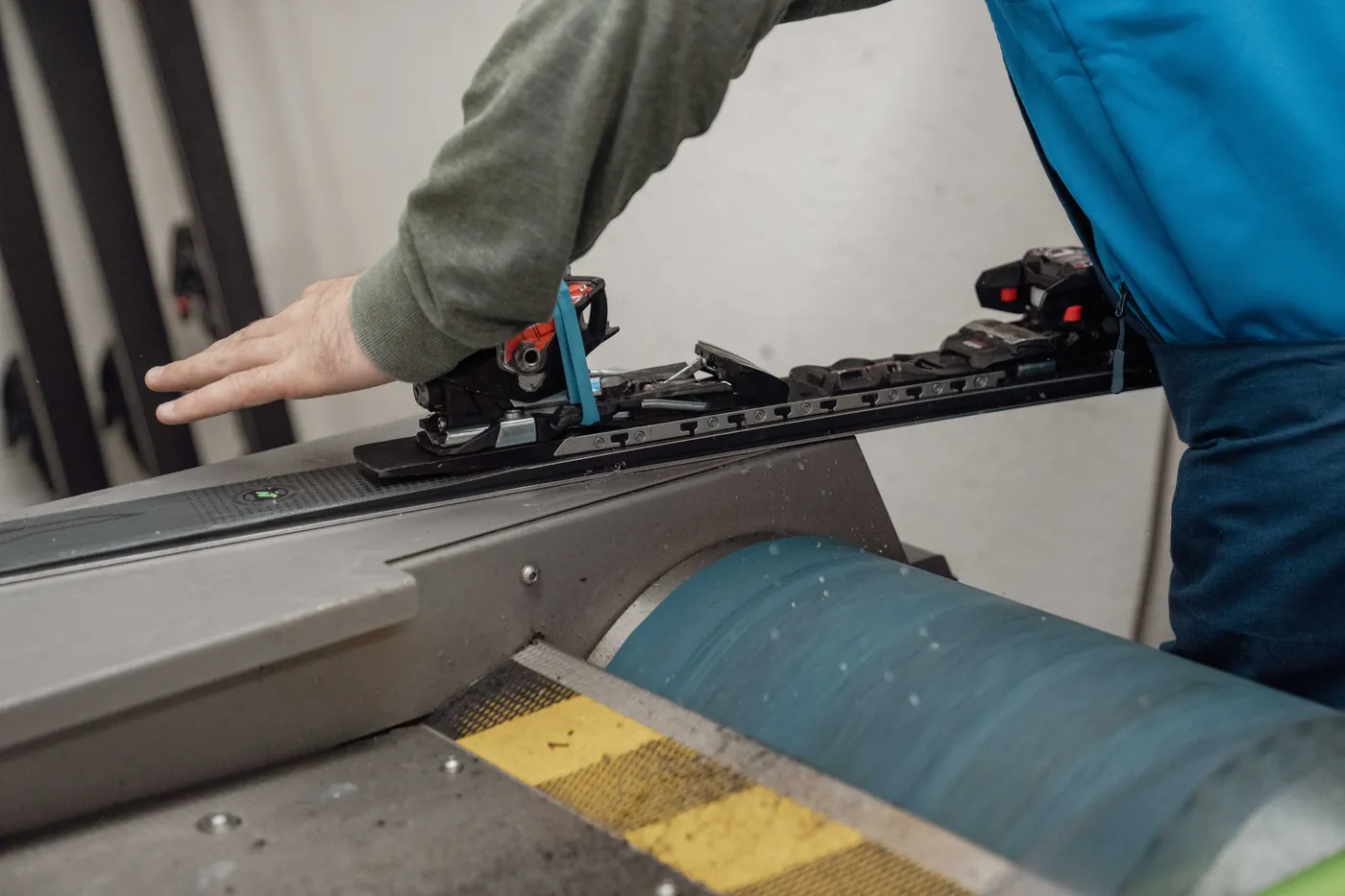 Ski wird an der Schleifmaschine in der Werkstatt bearbeitet